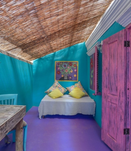 Boho Luxe Room at Mammaloe’s Aruba with turquoise walls, daybed and pink door
